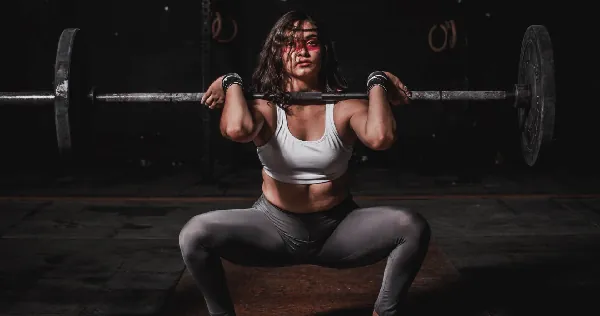 Woman performing front squat with barbell at The A Team Women's Fitness Dunnellon FL